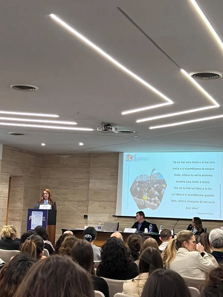 Francesca Magostini al leggio durante il Congresso Nazionale sulla disprassia, davanti a una sala piena